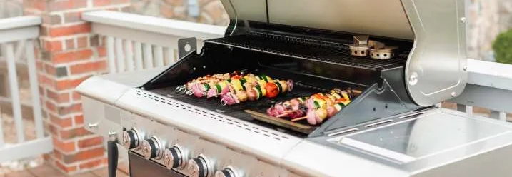 Gasgrill mit geöffnetem Deckel und Grillgut